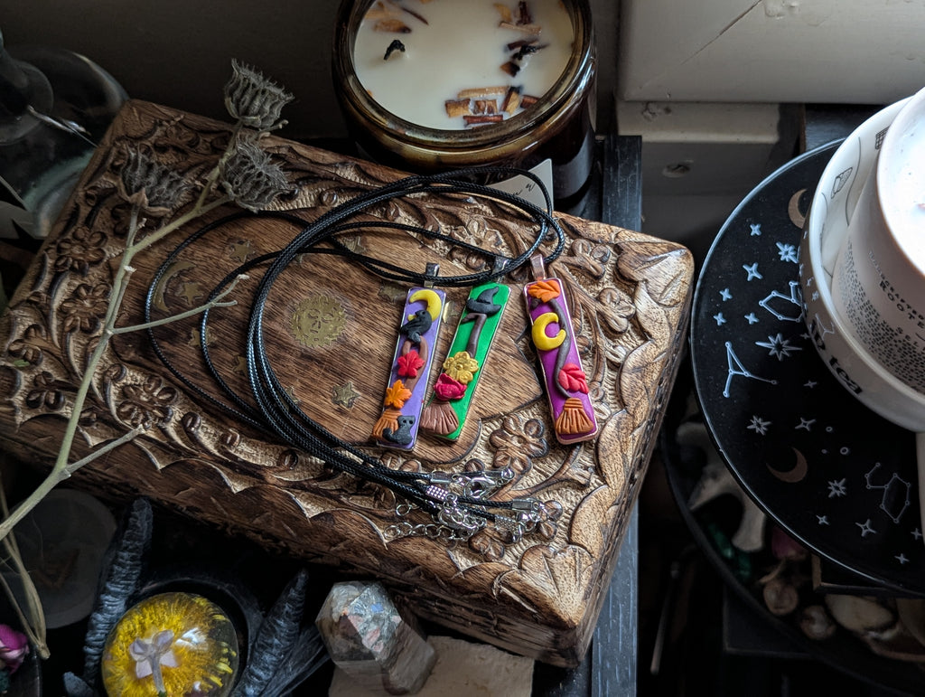 Handmade clay broom pendants for energy clearing and practical magic