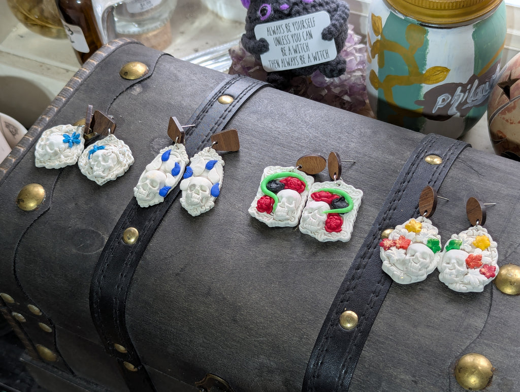 Hand-sculpted seasonal skull earrings attached to woodcogs with hypoallergenic posts