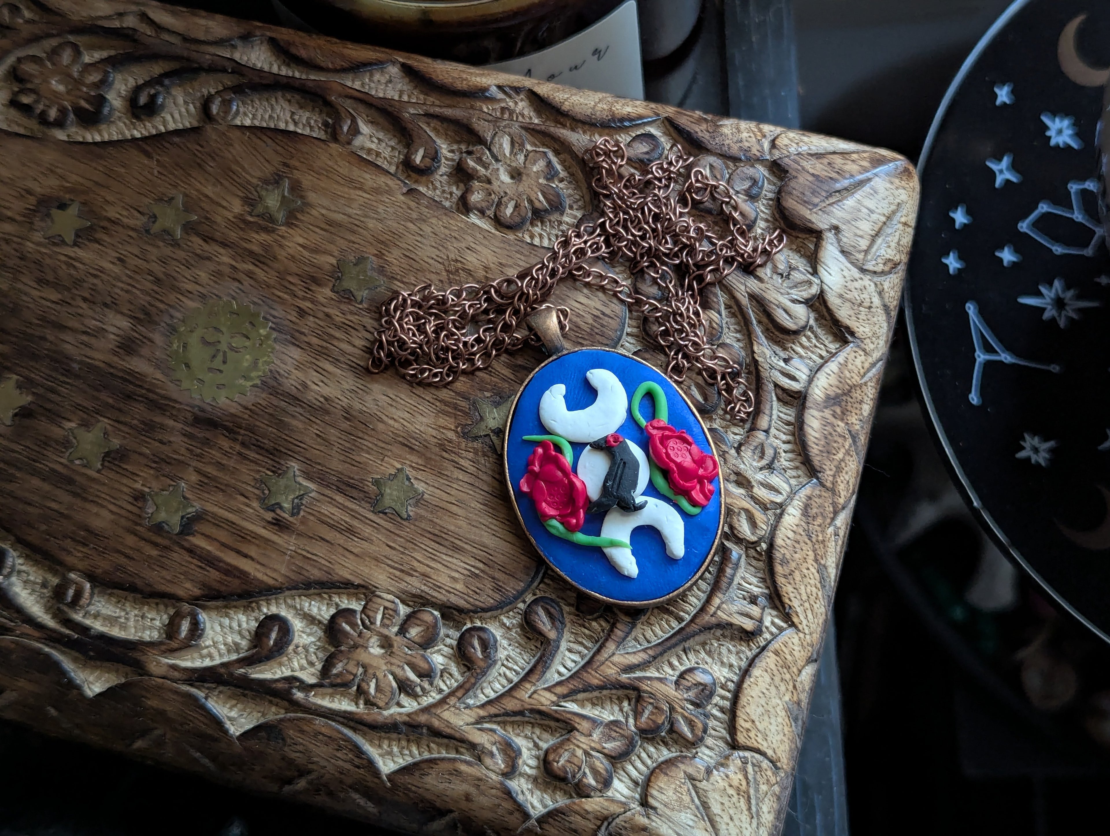 Hand sculpted clay raven moon necklace with three lunar phases