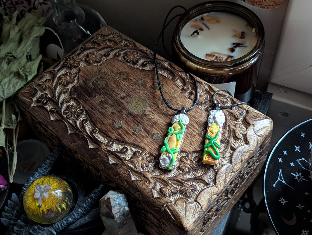 Castle Window necklace hand-sculpted from polymer clay with creeping vines and white flowers