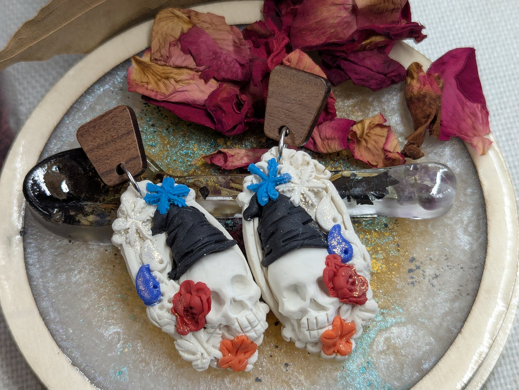 Hand-sculpted clay witch art featuring an ornate antique-style frame, skull, witch hat, and seasonal symbols representing the four seasons.