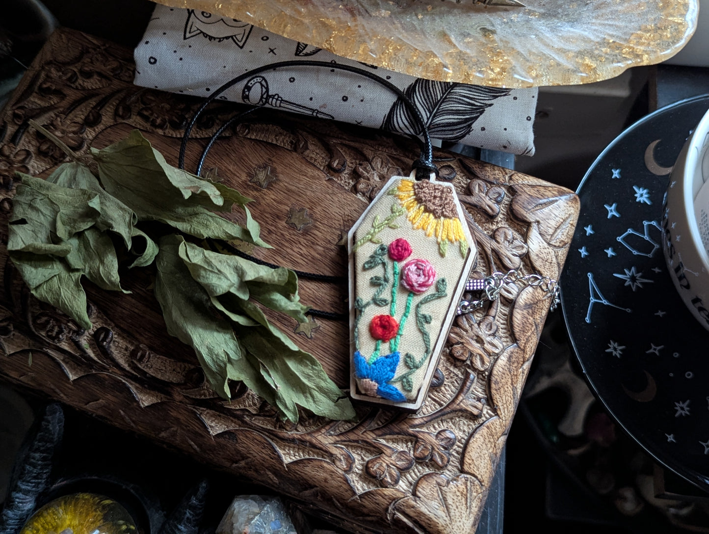 Hand embroidered coffin fiber art necklace with vibrant colors on a black cord, one of a kind gothic witchy statement jewelry