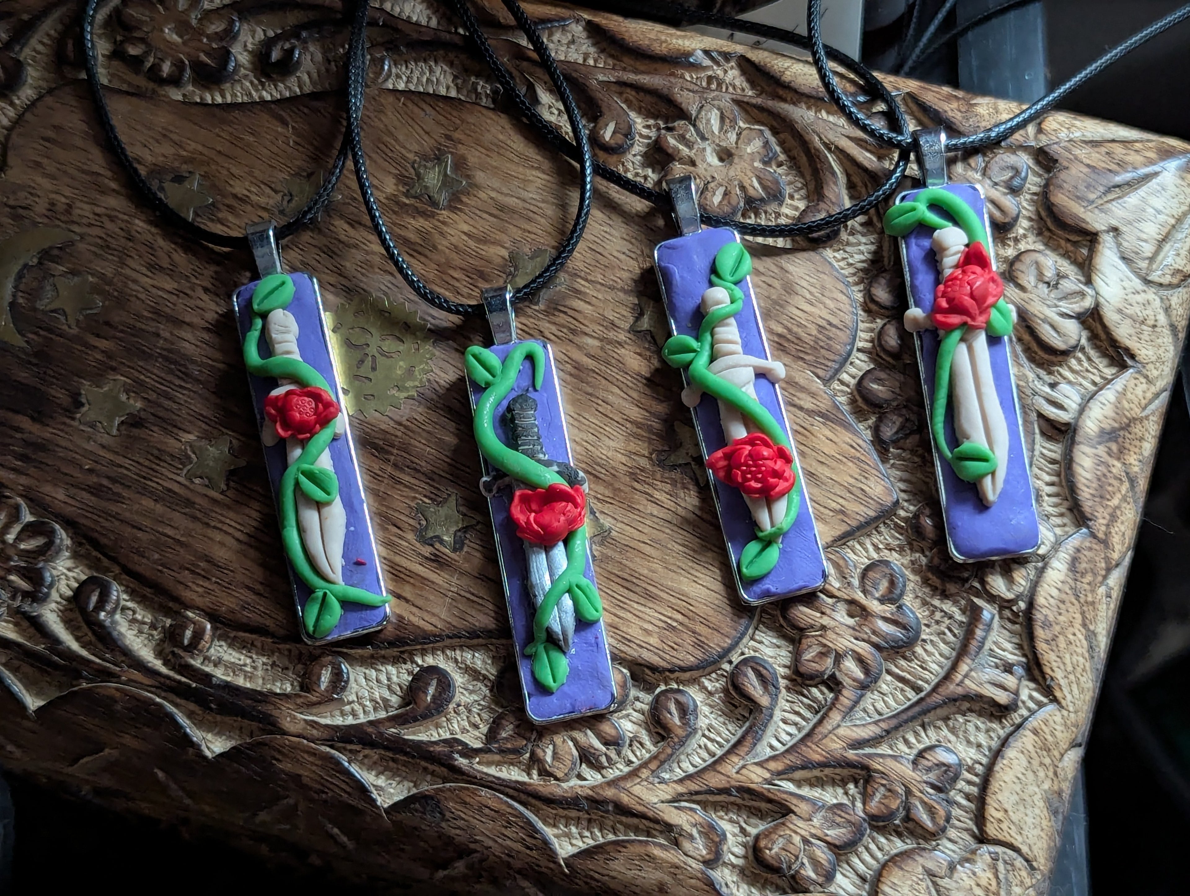 Hexcalibur hand-sculpted clay sword necklace wrapped with vines and roses